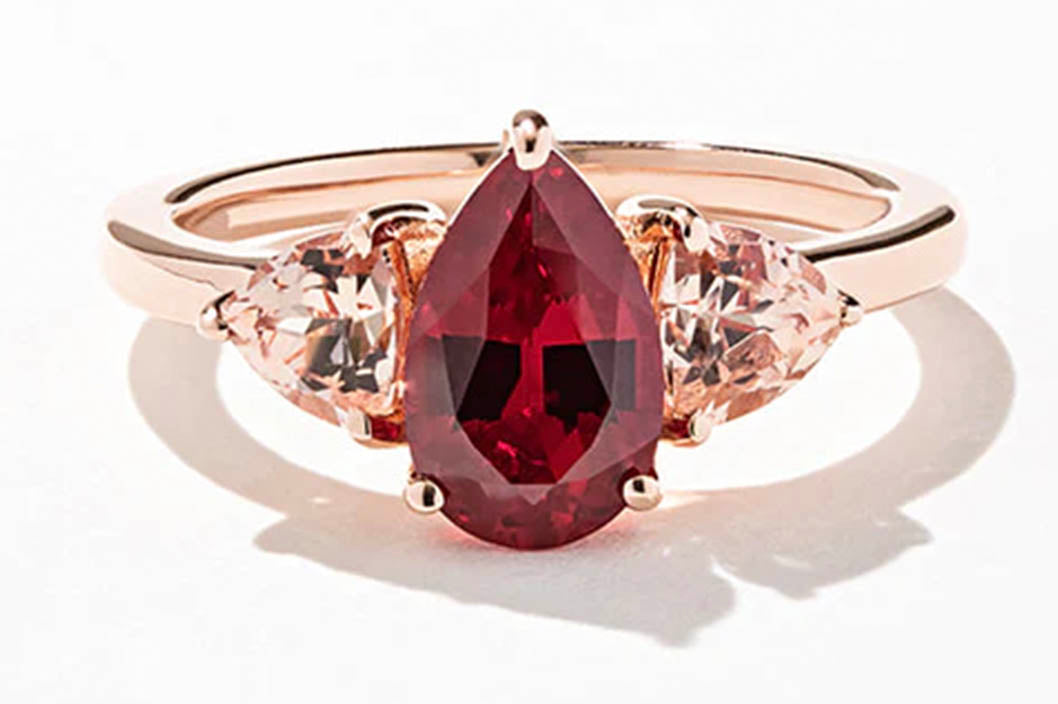 An image of a beautiful finished rose gold MiaDonna custom ring featuring a pear-cut ruby centerstone flanked by trillion champagne sapphires signifies step three of building your own custom ring: the handcrafting of your jewelry.