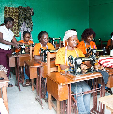 Women learning to use sewing machines at The Greener Diamond partnership Center for Women's Empowerment, a The Greener Diamond Project in Liberia