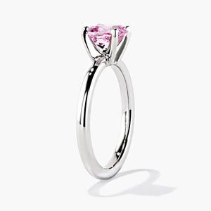 traditional solitaire engagement ring with a cushion cut lab grown pink champagne sapphire gemstone center stone set in 14k white gold recycled metal