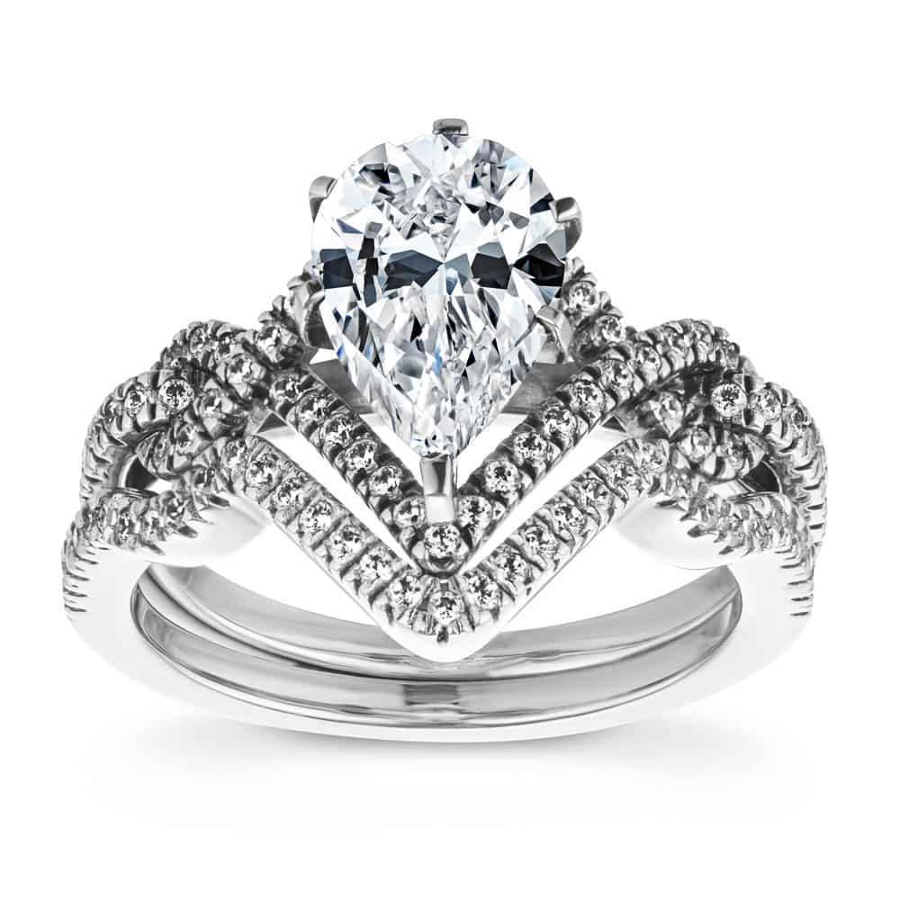 Shown with a 1.0ct Pear cut Lab-Grown Diamond with a diamond accented halo and twisted detail band in recycled 14K white gold with matching wedding band, can be purchased together for a discounted price 