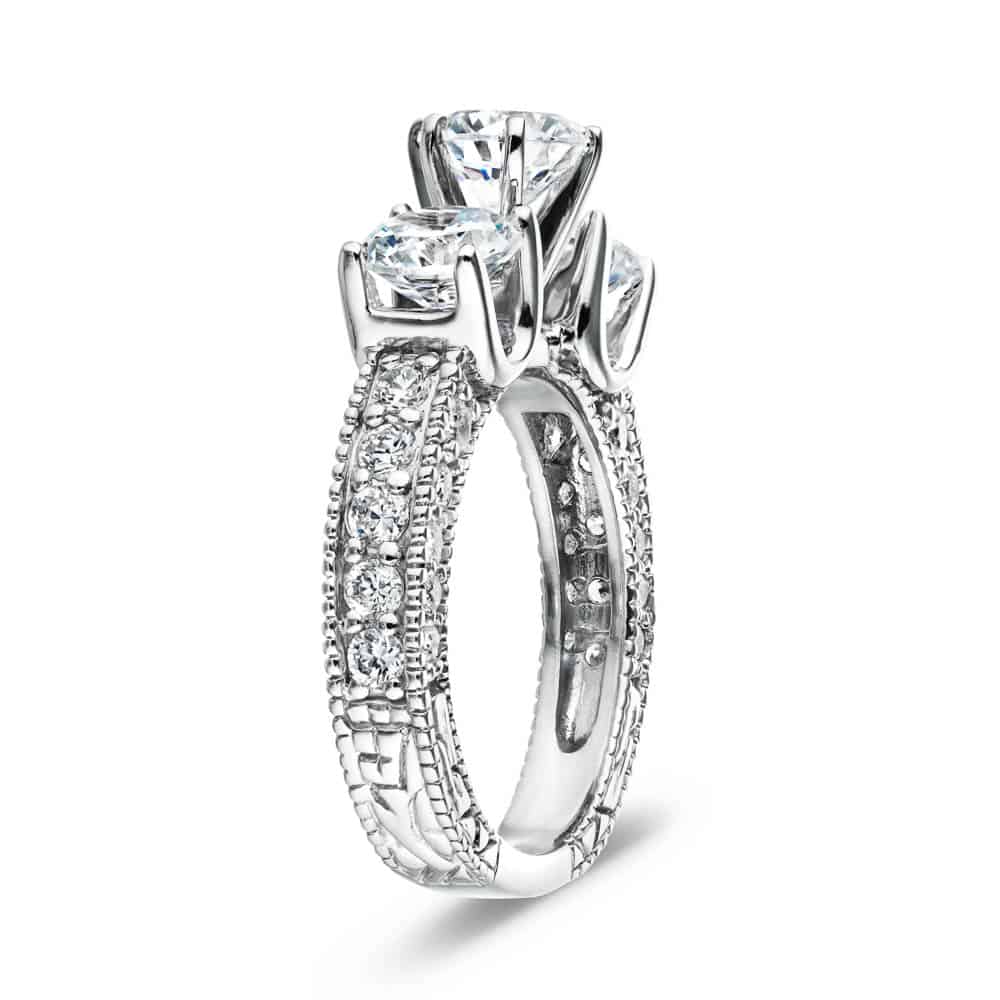 Shown with three Round cut Lab-Grown Diamonds and filigree detailing and accenting diamonds on the band in recycled 14K white gold | vintage three stone engagement ring Shown with three Round cut Lab-Grown Diamonds and filigree detailing and accenting diamonds on the band in recycled 14K white gold