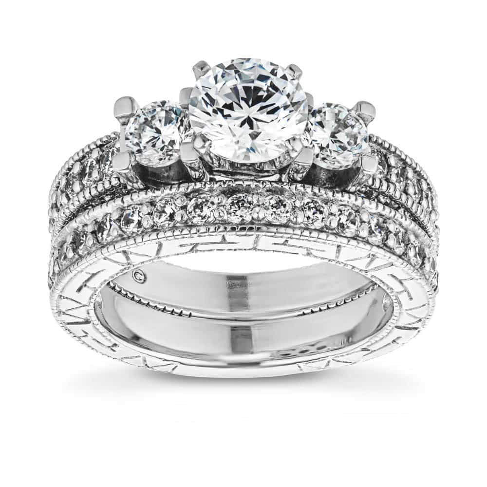 Shown with three Round cut Lab-Grown Diamonds and filigree detailing and accenting diamonds on the band in recycled 14K white gold and matching wedding band, can be purchased together for a discounted price