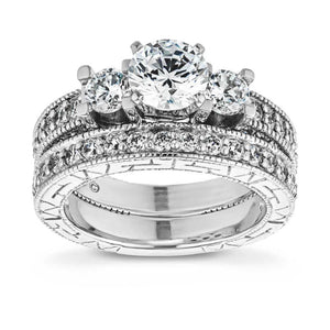  vintage three stone engagement ring Shown with three Round cut Lab-Grown Diamonds and filigree detailing and accenting diamonds on the band in recycled 14K white gold and matching wedding band