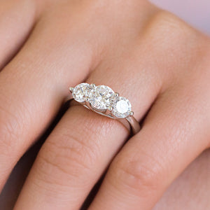 Beautiful three stone engagement ring with trellis set round cut lab grown diamonds in 14k white gold shown worn on hand