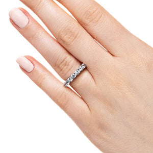 Ethical diamond wedding band with 7 basket set recycled round cut diamonds in 14k white gold shown worn on hand