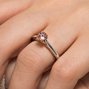 Lab grown champagne pink sapphire engagement ring with two tone 14k white gold and rose gold worn on hand