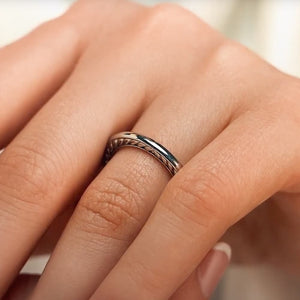 Unique stackable wedding ring with a braided rope design inlay in two tone 14k white gold and rose gold shown worn on hand