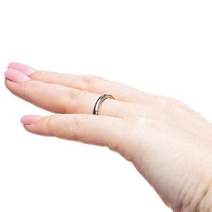 Wedding band with a braided metal design inlay in two tone 14k white gold and rose gold shown worn on hand sideview