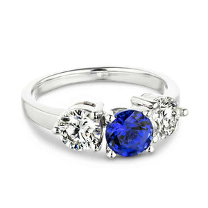 Three stone engagement with round cut lab grown diamonds and lab created blue sapphire center stone in 14k white gold