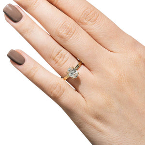 Hidden halo engagement ring with 1.5ct oval cut lab grown diamond in 14k yellow gold shown worn on hand