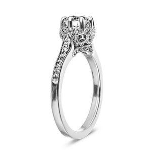 Antique style diamond accented engagement ring with an 8 prong crown style head holding 1ct round cut lab grown diamond with filigree and milgrain detailing in 14k white gold shown from side