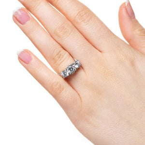 Three stone engagement ring with round cut lab grown diamonds in 14k white gold worn on hand