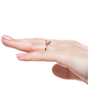 Engagement ring with 1ct cushion cut lab grown diamond with two diamond side stones in 14k rose gold worn on hand sideview