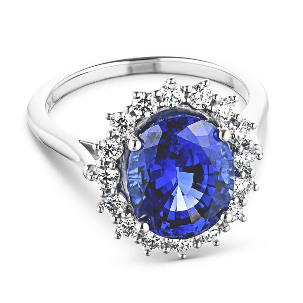 Shown with 3ct Oval Cut Lab Grown Blue Sapphire in 14k White Gold|Vintage style engagement ring with floral design halo around a 3ct lab created blue sapphire in 14k white gold