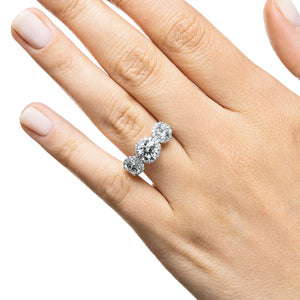 Three stone triple halo engagement ring with round cut lab grown diamonds in 14k white gold shown worn on hand