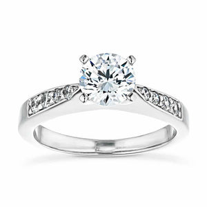 Modern style sleek accented engagement ring with a 1ct round cut lab grown diamond and channel set diamonds in 14k white gold