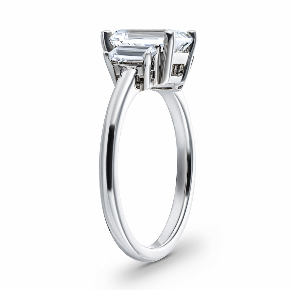 Shown with 1.75ct Emerald Cut Lab Grown Diamond in 14 White Gold|Ethical three stone engagement ring with 1.75ct emerald cut lab grown diamond center stone and two baguette cut diamond side stones in 14k white gold