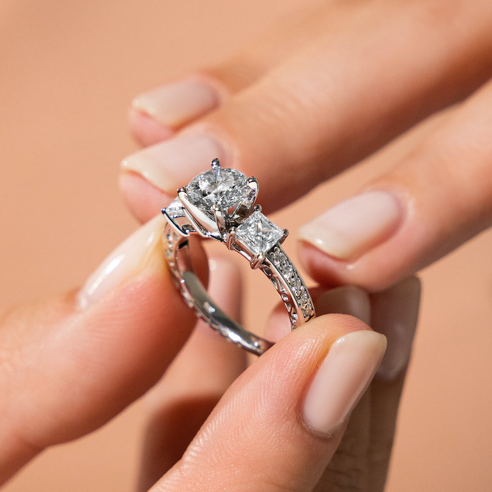 Shown with Three Princess Cut Lab Grown Diamonds Set in 14k White Gold|Vintage style three stone engagement ring with princess cut lab grown diamonds and antique style scroll detailing in 14k white gold