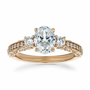  Vintage style rose gold engagement ring featuring beautiful milgrain detailing surrounding accenting diamonds with a 1ct oval cut lab created diamond surrounded by two round cut diamond side stones