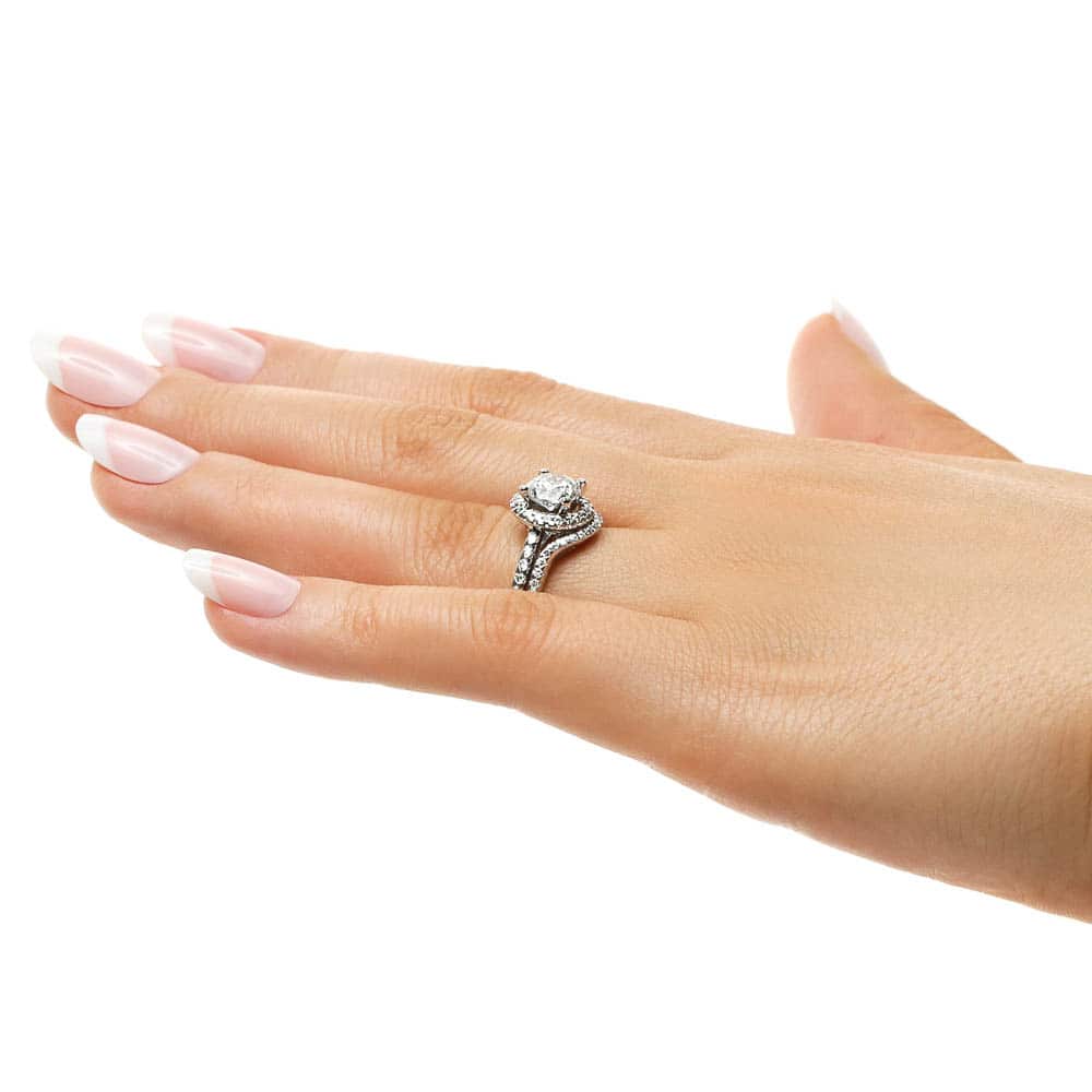 Shown with a 1.0ct Round cut Lab-Grown Diamond with a diamond accented halo and band in recycled 14K white gold with matching wedding band, can be purchased as a set for a discounted price