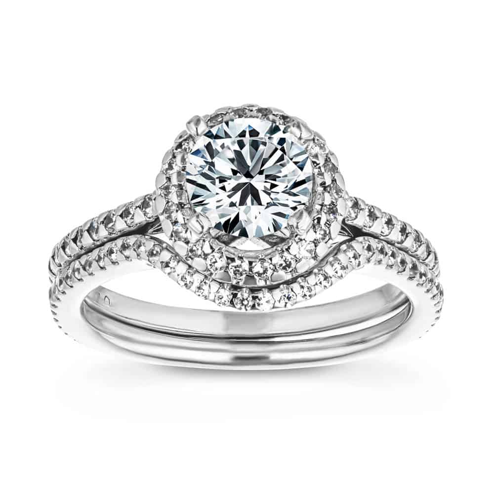 Shown with a 1.0ct Round cut Lab-Grown Diamond with a diamond accented halo and band in recycled 14K white gold with matching wedding band, can be purchased as a set for a discounted price