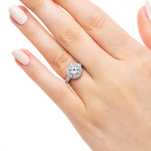 Diamond accented halo engagement ring with 1ct round cut lab grown diamond in 14k white gold worn on hand