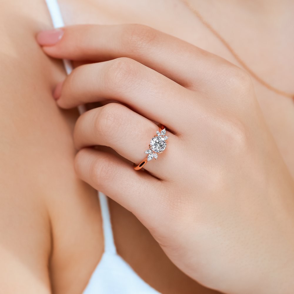 Shown here with a 1.0ct Round Cut Lab Grown Diamond center stone in 14K Rose Gold|floral inspired diamond accented engagement ring with round cut lab grown diamond center stone set in 14k rose gold metal