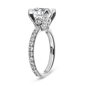 Vintage style diamond accented engagement ring with peek-a-boo diamonds under a 1.5ct round cut lab grown diamond in a 14k white gold band shown from side