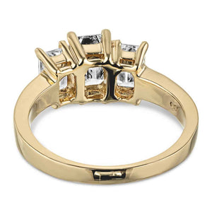 Three stone engagement ring with emerald cut lab grown diamonds in 14k yellow gold band shown from back