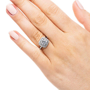 Vintage style cushion shape diamond halo engagement ring with 1.5ct round cut lab grown diamond in 14k white gold band worn on hand