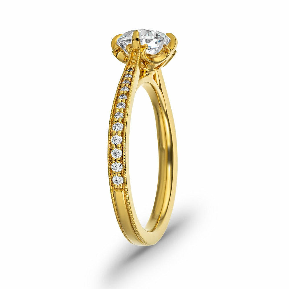 Shown with a 1ct Round cut Lab Grown Diamond in 14k Yellow Gold|Vintage style engagement ring with diamond accented milgrain detailed band and a 1ct round cut lab created diamond held in a 4 claw prong head in 14k yellow gold