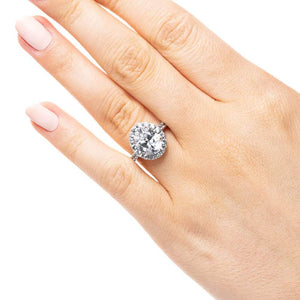 Diamond accented halo engagement ring with 2ct oval cut lab grown diamond in 14k white gold band worn on hand