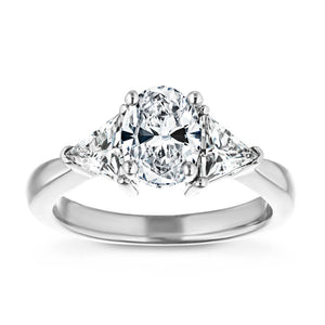 Beautiful conflict free three stone engagement ring with 1ct oval cut lab grown diamond and two 0.50 triangle cut diamond side stones in 14k white gold band