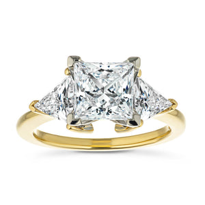 Beautiful ethical three stone engagement ring with 1.5ct princess cut lab grown diamond and two 0.50 triangle cut diamond side stones in 14k yellow gold band