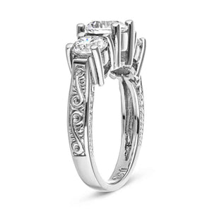 Vintage style three stone engagement ring with round cut lab created diamonds in 14k white gold setting with filigree detailing shown from side