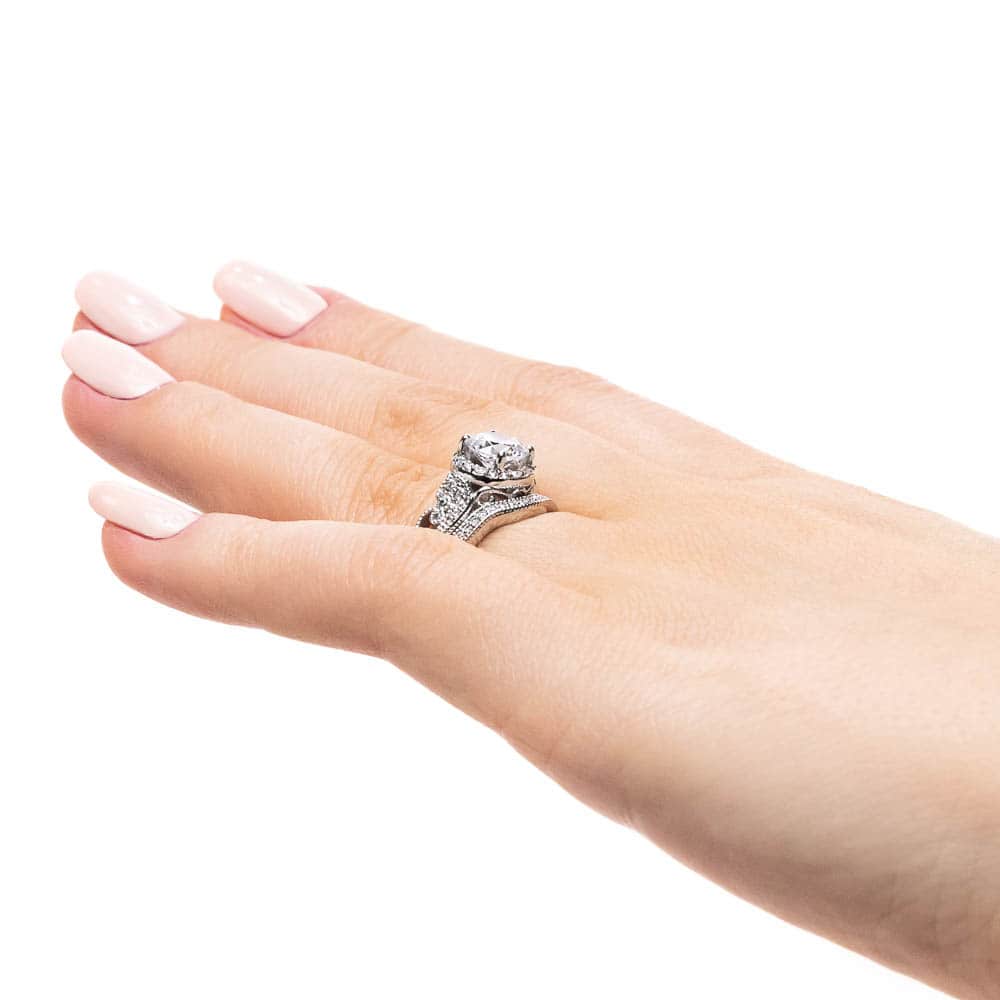Shown with a 1.0ct Round cut Lab-Grown Diamond with diamond accented halo and filigree detailed band in recycled 14K white gold with matching wedding band, can be purchased together for a discounted price
