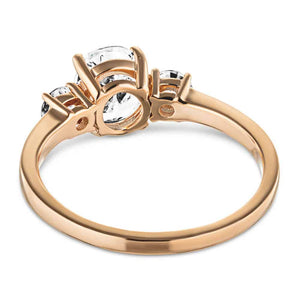 Three stone engagement ring with 1ct oval cut lab grown diamond and two round cut lab diamond shoulder stones in basket style 14k rose gold setting shown from back