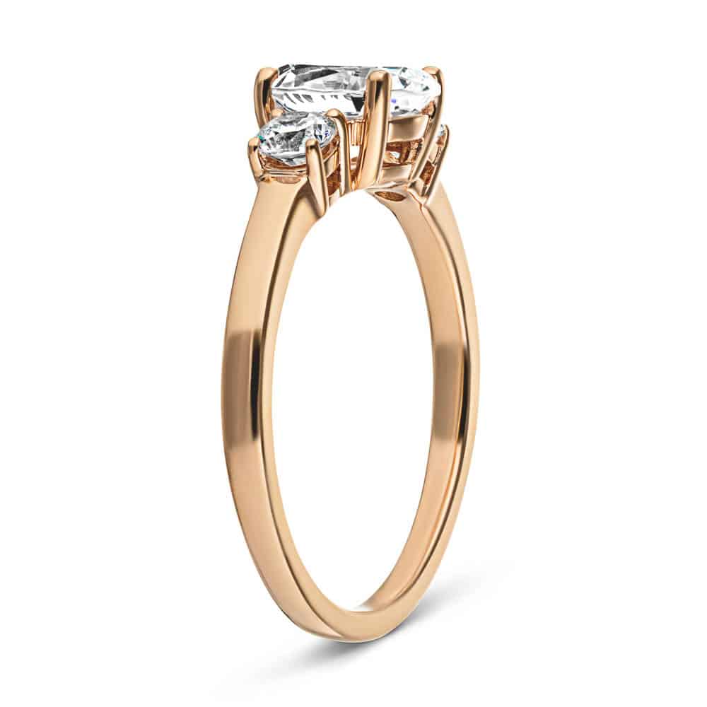 Shown with 1ct Oval Cut Lab Grown Diamond with Two Round Cut Lab Diamonds in 14k Rose Gold|Beautiful unique three stone engagement ring with 1ct oval cut lab grown diamond and two round cut lab diamond shoulder stones in basket style 14k rose gold setting
