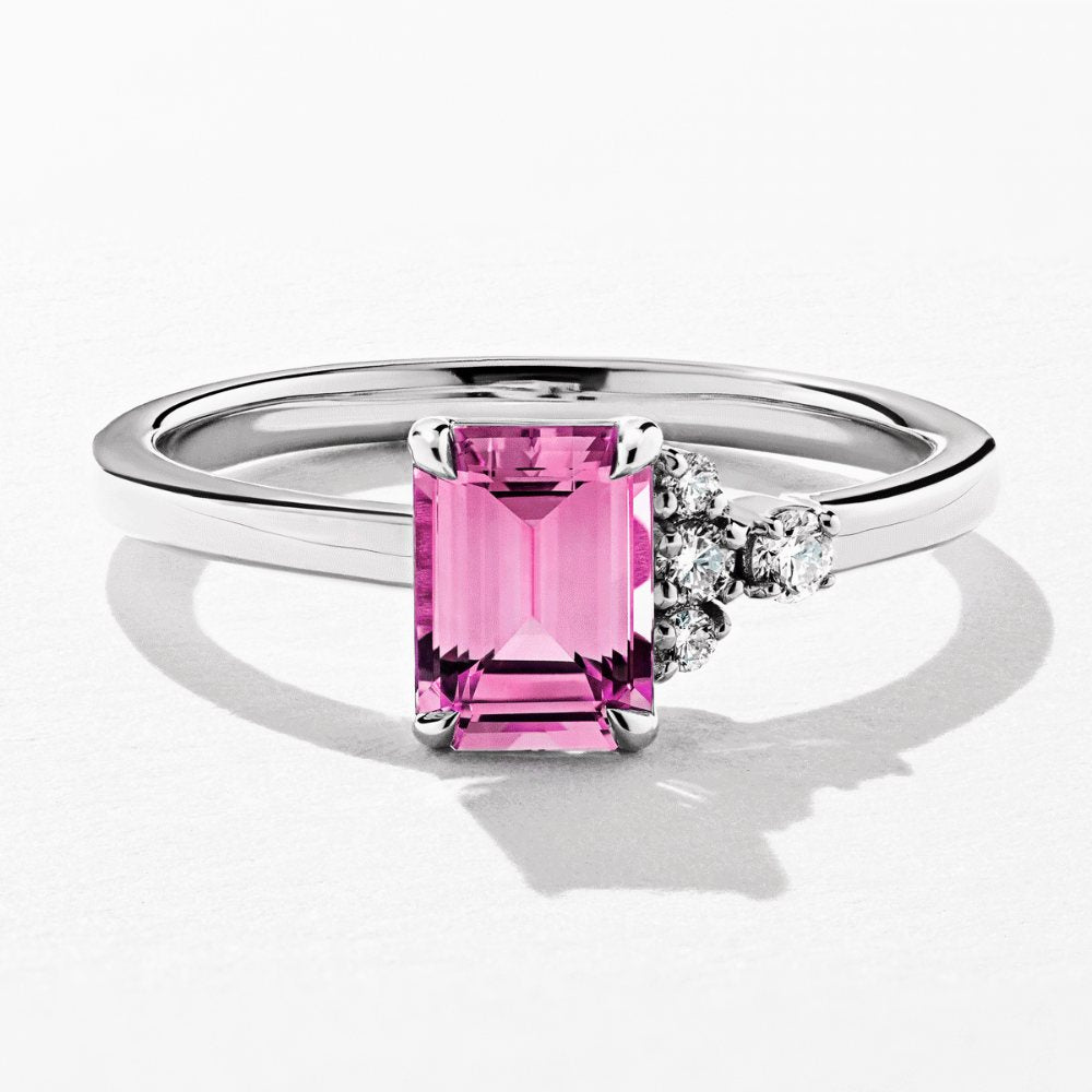 Shown here with an Emerald Cut Pink Sapphire Lab Grown Gemstone|solitaire asymmetrical engagement ring with a lab grown gemstone pink sapphire emerald cut with accenting lab grown diamonds by MiaDonna