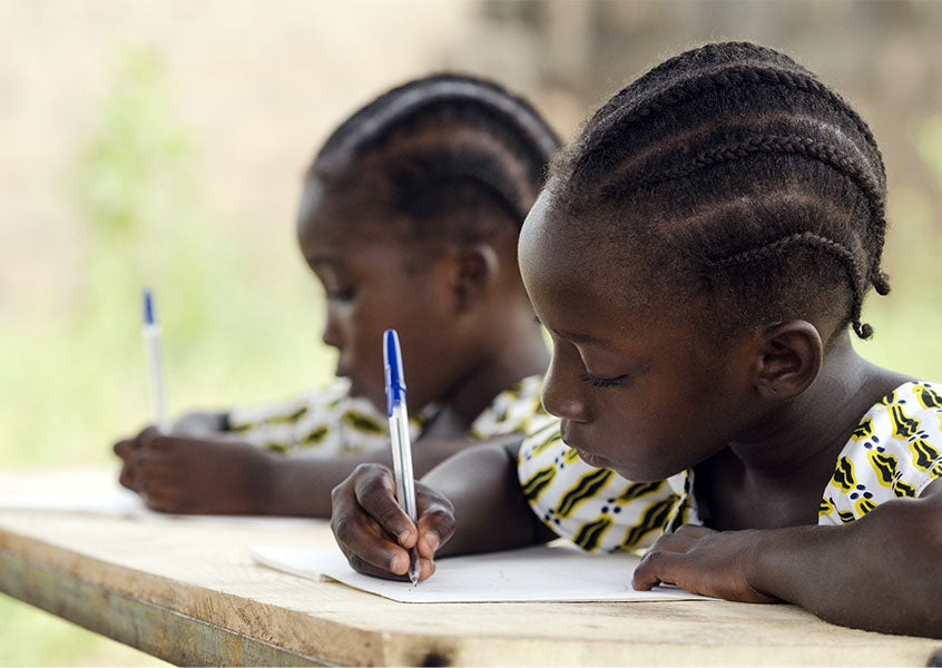 Two students work at their desk as part of The Greener Diamond partnership DRC PRIMARY EDUCATION INITIATIVE, DEMOCRATIC REPUBLIC OF THE CONGO