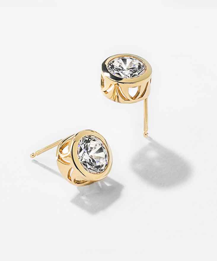 Lab-Grown Diamond earrings in a yellow gold setting on a white background