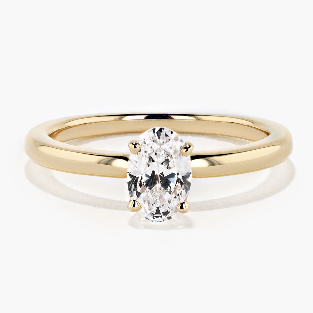 Shown in 14K Yellow Gold with an Oval Cut Center Stone|traditional solitaire engagement ring in 14k recycled yellow gold with an oval cut diamond hybrid by MiaDonna