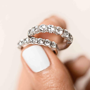 Two lab grown diamond wedding bands held in hand