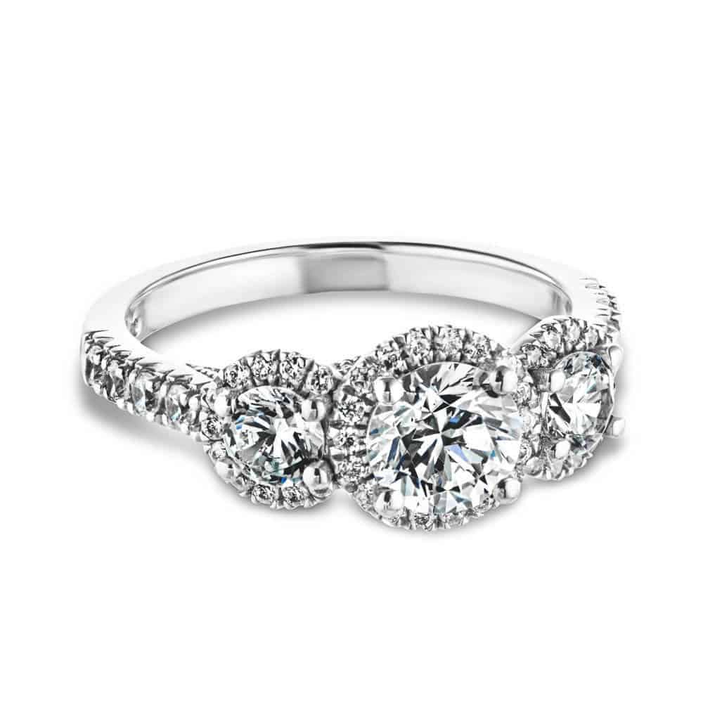 Shown with Round Cut Lab Grown Diamonds in 14k White Gold|Luxurious three stone engagement ring with round cut lab grown diamonds surrounded by diamond halos in 14k white gold