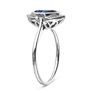 Vintage style engagement ring with bezel set lab grown blue sapphire and accenting diamonds in 14k white gold shown from side