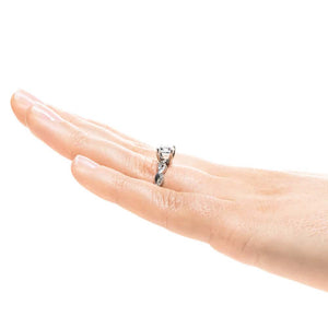 Nature inspired engagement ring with twisted diamond accented band featuring 1ct round cut lab grown diamond in 14k white gold worn on hand sideview