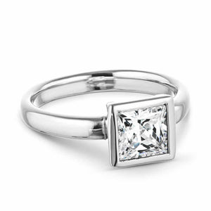 Modern sleek minimalistic solitaire engagement ring with 1.5ct princess cut bezel set lab grown diamond in 14k white gold