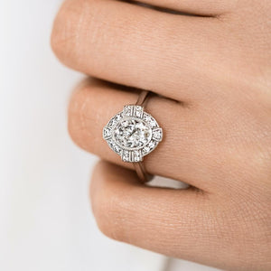 Antique style engagement ring with milgrain detail diamond accented halo in 14k white gold shown worn on hand