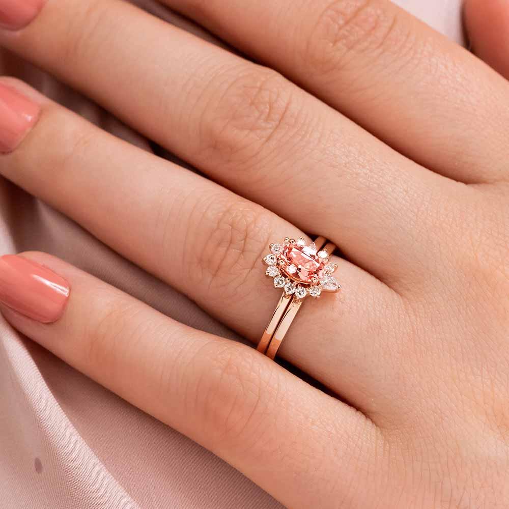 Show with a 1.0ct Oval cut Champagne Sapphire lab created gemstone with a half diamond halo in recycled 14K rose gold and matching wedding band 