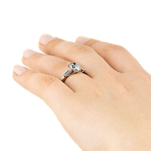 Beautiful three stone engagement ring with trellis set 2ct oval cut lab grown diamond amid baguette side stones in 14k white gold shown worn on hand